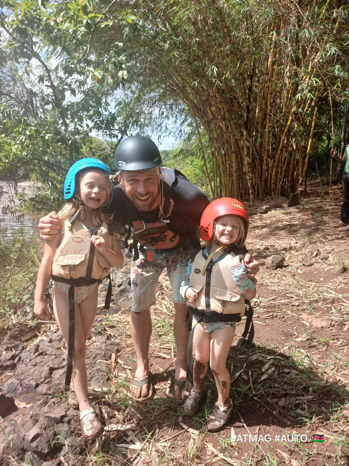Curt with his two daughters in helmets and life jackets after a river run