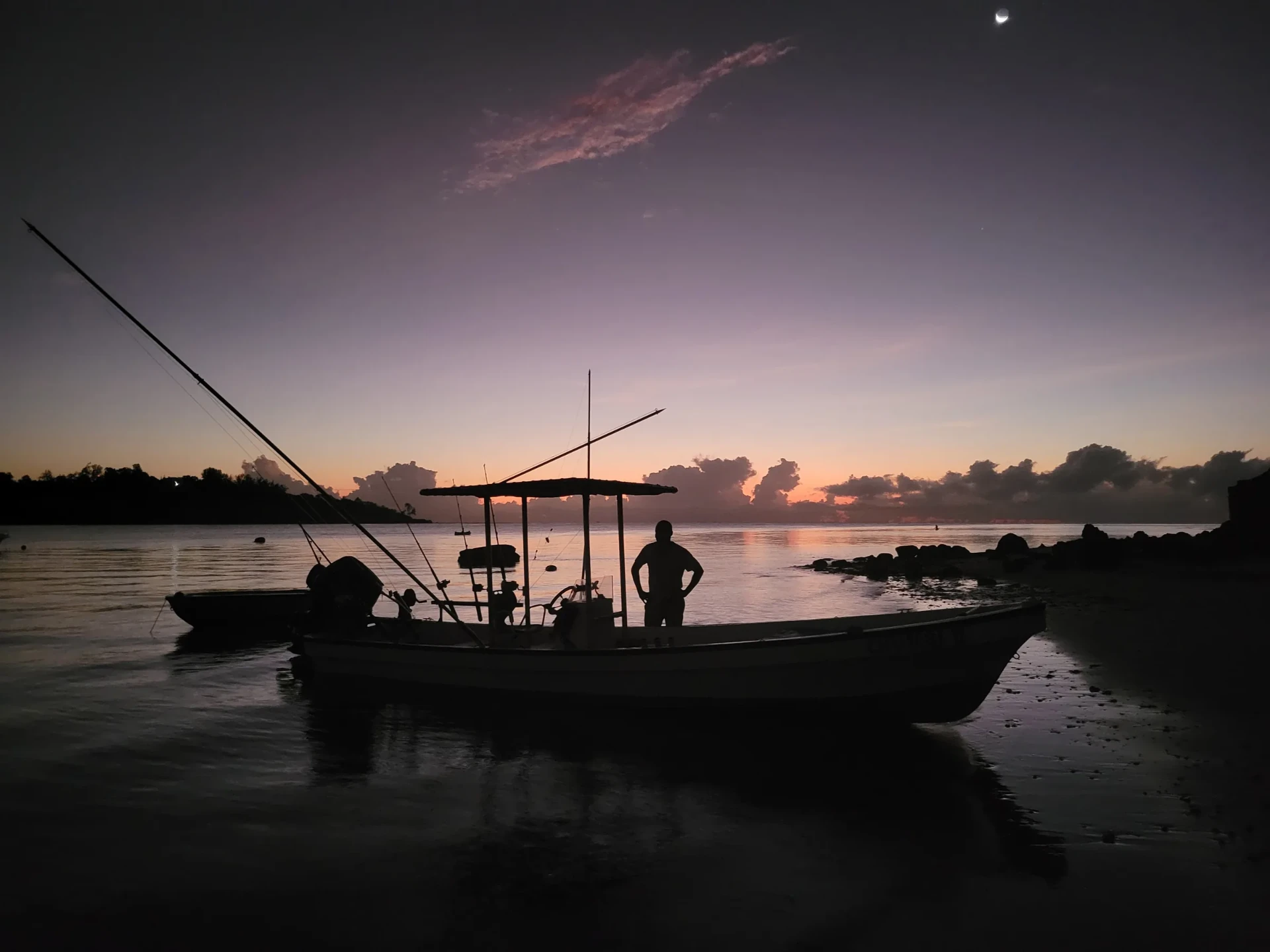 Fishing boat at dawn on the Kenyan coast under a crescent moon