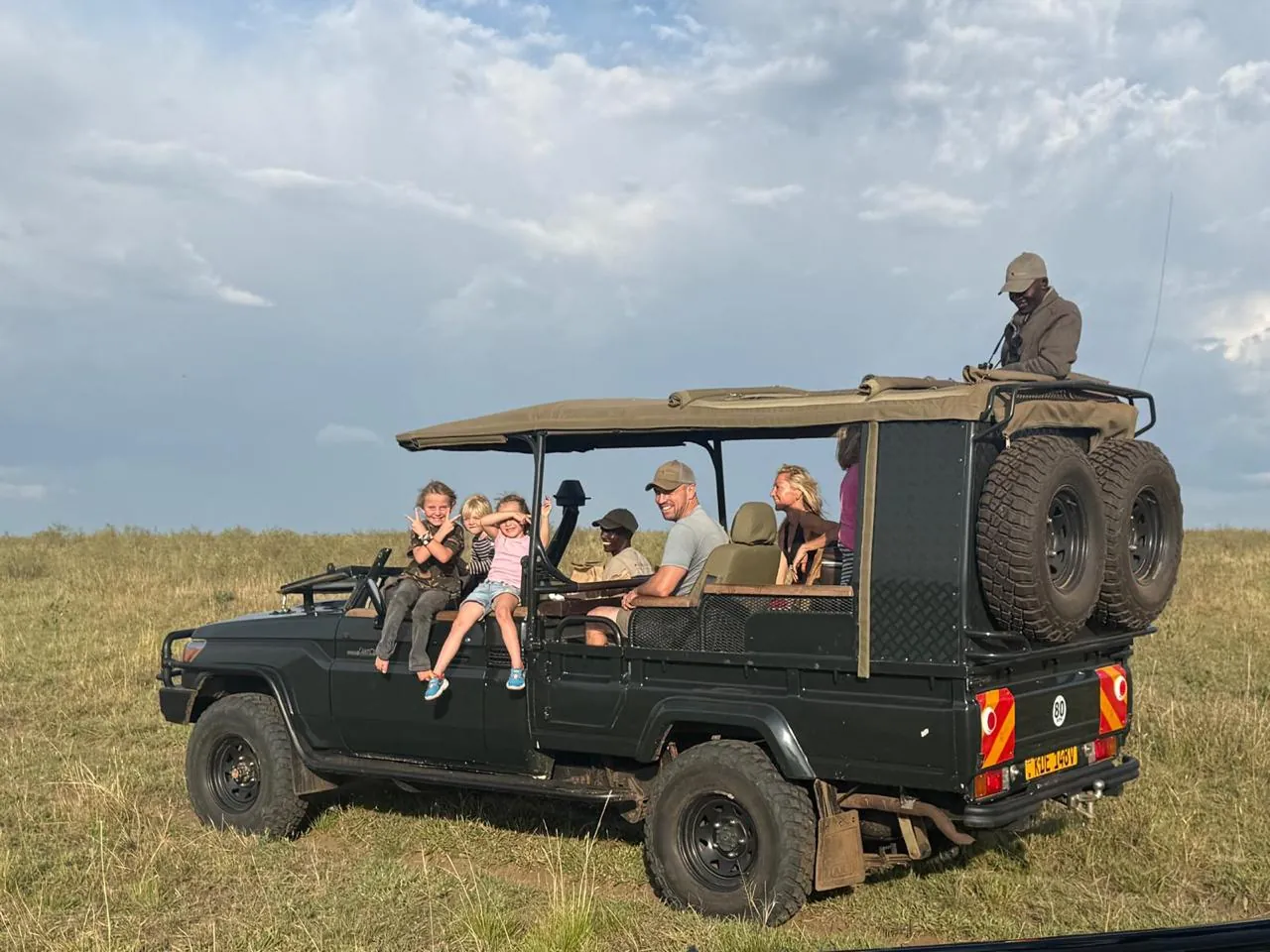 Family on an open-sided safari vehicle in the Maasai Mara