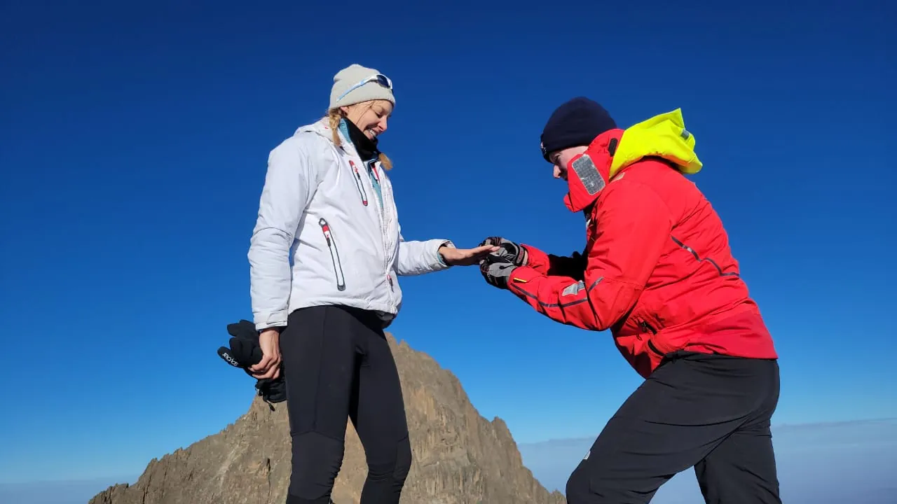 Couple sharing a proposal on the summit of Mount Kenya